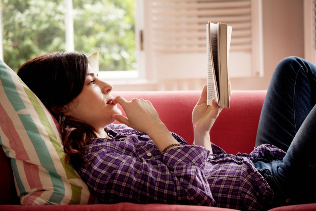 Woman reading book on couch